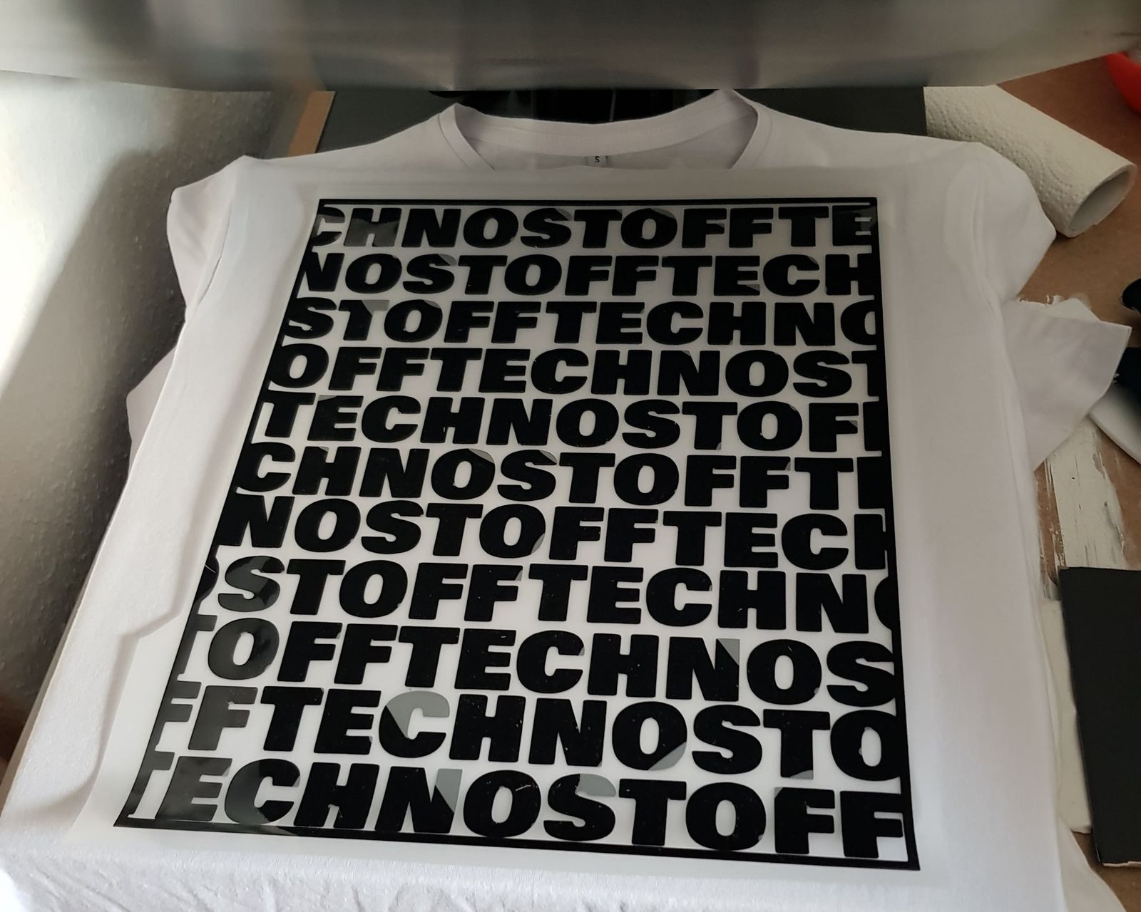Weißes T-Shirt mit Allover-Textdruck auf Transferpresse – Stoff³ Kassel